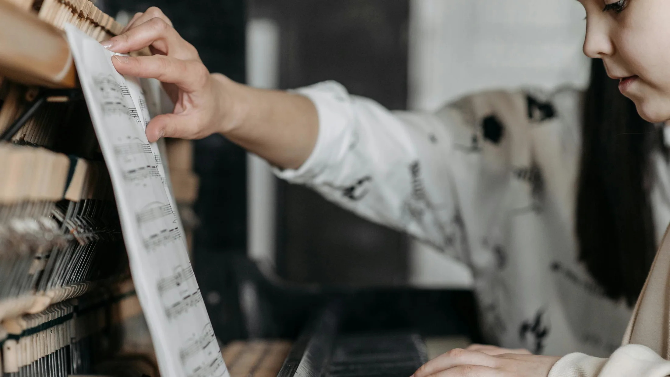A piano lesson in a quiet studio with sheet music and focused hands.